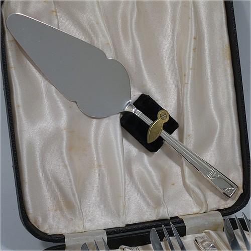 A very pretty and unusual Sterling Silver set of six pastry forks and cake server, having single-struck Art Deco style handles, and three tined forks, all in their original cream satin and black velvet-lined presentation box, with an extra cake server in the lid. Made by Emile Viner of Sheffield in 1990. The dimensions of these fine hand-made silver pastry forks are length 14 cms (5.5 inches), and they weigh a total of 174g (5.6 troy ounces).