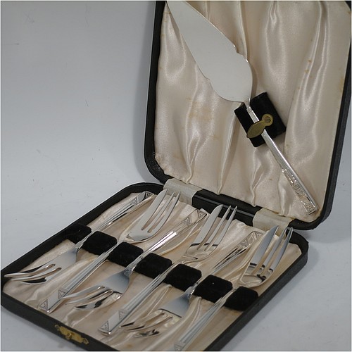 A very pretty and unusual Sterling Silver set of six pastry forks and cake server, having single-struck Art Deco style handles, and three tined forks, all in their original cream satin and black velvet-lined presentation box, with an extra cake server in the lid. Made by Emile Viner of Sheffield in 1990. The dimensions of these fine hand-made silver pastry forks are length 14 cms (5.5 inches), and they weigh a total of 174g (5.6 troy ounces).