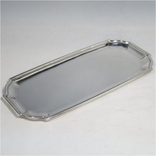A Sterling Silver heavy Georgian style pen tray, having a rectangular body with shaped ends, a reeded and panelled border, and a plain ground, sitting on a flat base. Made by D. & J. Welby of London in 1927. The dimensions of this fine hand-made silver pen tray are length 22 cms (8.75 inches), width 10 cms (4 inches), and it weighs approx. 240g (7.7 troy ounces).    