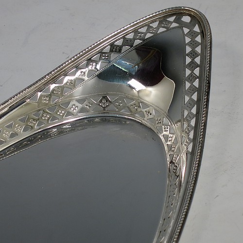 A very pretty Antique Victorian Sterling Silver pen tray, having an oval body, an applied bead border with bands of hand-engraved and hand-pierced geometrical decoration, and sitting on a flat base. Made by Charles Stuart Harris of London in 1899. The dimensions of this fine hand-made antique silver pen tray are length 27 cms (10.5 inches), width 10 cms (4 inches), and it weighs approx. 137g (4.4 troy ounces).