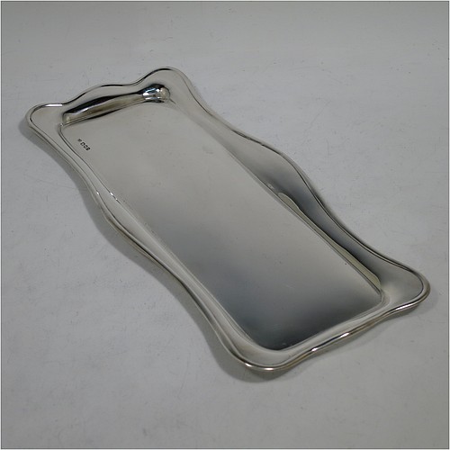 A very handsome Sterling Silver pen tray, having a rectangular body with a wavy raised edge and rounded corners, an applied reeded border, and a plain ground, sitting on a flat base. Made by Robert Pringle of London in 1919. The dimensions of this fine hand-made silver pen tray are length 24 cms (9.5 inches), width 10 cms (4 inches), and it weighs approx. 119g (3.8 troy ounces).