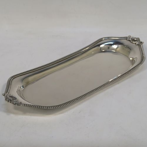 A very handsome Antique Georgian Sterling Silver pen tray, having a shaped rectangular body, with a plain flat ground, applied gadroon borders and cast shells at either end, and all sitting on a flat base. This beautiful antique silver pen tray was made in London in 1814. The dimensions of this fine hand-made antique silver pen tray are length 24 cms (9.5 inches), width 10 cms (4 inches), and it weighs approx. 140g (4.5 troy ounces).  