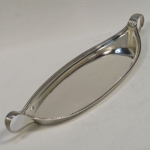 A very handsome Antique Georgian Sterling Silver pen tray, having a very plain oval body with applied beaded borders, with looped and reeded side-handles, and all sitting on a flat base. This elegant antique silver pen tray was made by John Schofield of Lndon in 1779. The dimensions of this fine hand-made antique silver pen tray are length 25.5 cms (10 inches), width 9.5 cms (3.75 inches), and it weighs approx. 138g (4.5 troy ounces).   