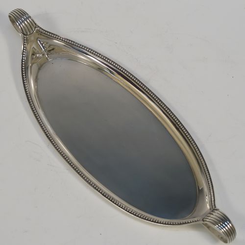 A very handsome Antique Georgian Sterling Silver pen tray, having a very plain oval body with applied beaded borders, with looped and reeded side-handles, and all sitting on a flat base. This elegant antique silver pen tray was made by John Schofield of Lndon in 1779. The dimensions of this fine hand-made antique silver pen tray are length 25.5 cms (10 inches), width 9.5 cms (3.75 inches), and it weighs approx. 138g (4.5 troy ounces).