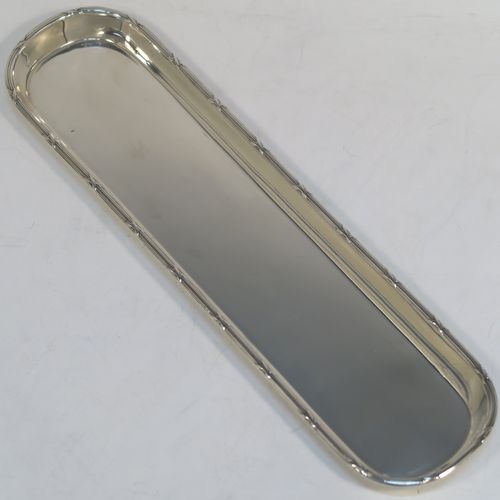 A very elegant Antique Sterling Silver pen tray, having a very plain rectangular body with rounded ends, an applied reed and ribbon border, and all sitting on a flat base. This handsome silver pen tray was made by Stokes and Ireland of Chester in 1914. The dimensions of this fine hand-made antique silver pen tray are length 24 cms (9.5 inches), width 6.5 cms (2.5 inches), and it weighs approx. 108g (3.5 troy ounces).
