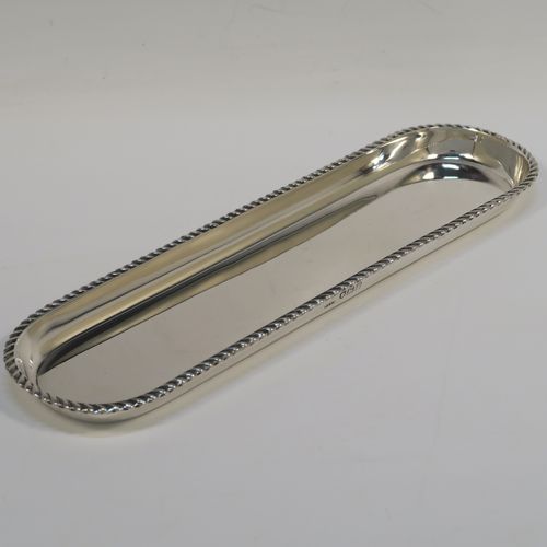 A handsome Antique Sterling Silver pen tray, having a rectangular body with rounded ends, an applied gadroon border, and all sitting on a flat base. This elegant silver pen tray was made by Stokes and Ireland of London in 1912. The dimensions of this fine hand-made silver pen tray are length 22.5 cms (8.75 inches), width 6 cms (2.3 inches), and it weighs approx. 97g (3 troy ounces).   