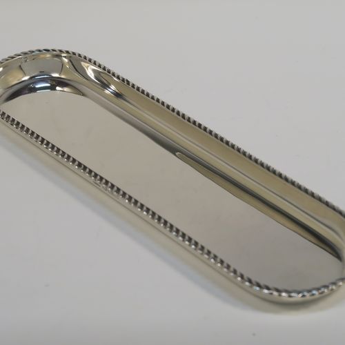 A handsome Antique Sterling Silver pen tray, having a rectangular body with rounded ends, an applied gadroon border, and all sitting on a flat base. This elegant silver pen tray was made by Stokes and Ireland of London in 1912. The dimensions of this fine hand-made silver pen tray are length 22.5 cms (8.75 inches), width 6 cms (2.3 inches), and it weighs approx. 97g (3 troy ounces).