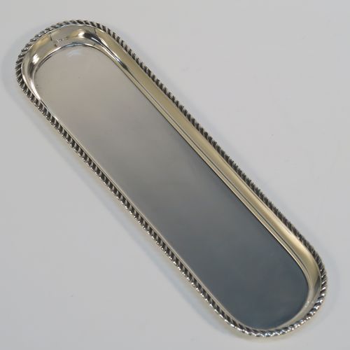 A handsome Antique Sterling Silver pen tray, having a rectangular body with rounded ends, an applied gadroon border, and all sitting on a flat base. This elegant silver pen tray was made by Stokes and Ireland of London in 1912. The dimensions of this fine hand-made silver pen tray are length 22.5 cms (8.75 inches), width 6 cms (2.3 inches), and it weighs approx. 97g (3 troy ounces).