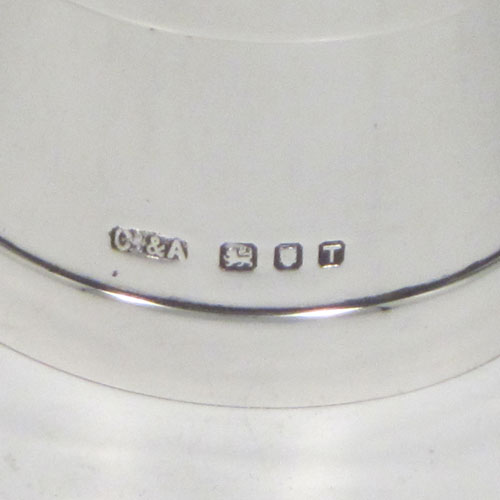 Sterling silver pair of pepper grinders, having plain tapering straight sided bodies with three applied bands, with knurled grinder finials, and both having good quality grinder mechanisms that work properly. Made by Collett and Anderson of London in 1954. The dimensions of these fine hand-made silver pepper grinders are height 8 cms (3 inches), and diameter at base 4.5 cms (1.75 inches).