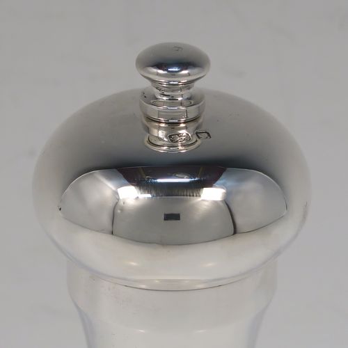 A large and handsome Sterling Silver pepper grinder, having a plain round baluster body, an original Peter Piper grinder mechanism, and a plain round finial. This elegant silver pepper grinder was made by W.E.V. of London in 1986. The dimensions of this fine hand-made silver pepper grinder are height 15 cms (6 inches), diameter at base 5 cms (2 inches), and it weighs approx. 185g (6 troy ounces).   