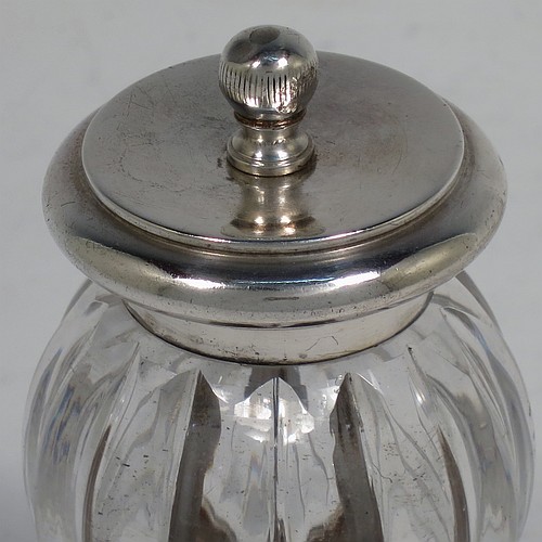 A handsome Antique Victorian Sterling Silver and hand-cut crystal pepper grinder, having a round crystal body with a hand-cut melon fluted pattern, plain round mounts top and bottom with knurled ball finial, and an original Peugeot grinding mechanism. Made by John Greene and Co., of Birmingham in 1888. The dimensions of this fine hand-made antique silver and crystal pepper grinder are height 9.5 cms (3.75 inches), and diameter at base 5.5 cms (2.25 inches).    
