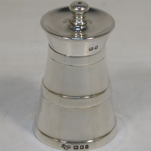 A very handsome Antique Edwardian Sterling Silver pepper grinder in a milk churn style, having a plain tapering straight sided body with three applied bands of decoration, with a knurled grinder finial, and a Peugeot grinder mechanism. This elegant antique silver pepper grinder was made by Goldsmiths and Silversmiths of London in 1903. The dimensions of this fine hand-made antique silver pepper grinder are height 8 cms (3 inches), and diameter at base 5 cms (2 inches).   