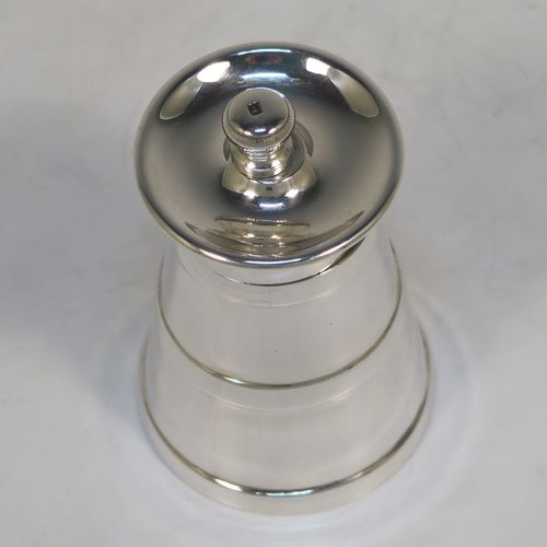 A very handsome Antique Edwardian Sterling Silver pepper grinder in a milk churn style, having a plain tapering straight sided body with three applied bands of decoration, with a knurled grinder finial, and a Peugeot grinder mechanism. This elegant antique silver pepper grinder was made by Goldsmiths and Silversmiths of London in 1903. The dimensions of this fine hand-made antique silver pepper grinder are height 8 cms (3 inches), and diameter at base 5 cms (2 inches).