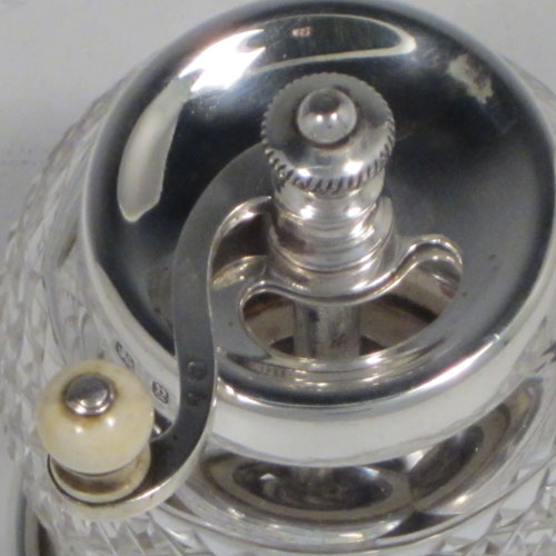Antique Victorian sterling silver and hand-cut crystal pepper grinder, having a round body with hobnail-cut pattern, plain round mounts top and bottom, an opening for adding the pepper corns that is revealed by twisting the top mount, a side-winding grinder arm with ivory finial, and an original Peugeot grinding mechanism. Made in Birmingham in 1898. The dimensions of this fine hand-made silver and crystal pepper grinder are height 9 cms (3.5 inches), and diameter at base 6.5 cms (2.5 inches). 