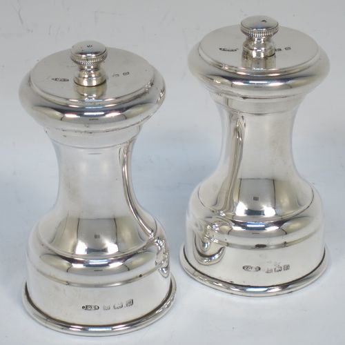 A very handsome pair of Antique Sterling Silver pepper grinders, having plain round baluster bodies, with original grinder mechanisms, and knurled finials. Made by John Grinsell and Sons of Birmingham in 1911. The dimensions of this fine pair of hand-made antique silver pepper grinders are height 8.5 cms (3.25 inches), diameter at bases 4.5 cms (1.75 inches), and they weigh approx. 186g (6 troy ounces).