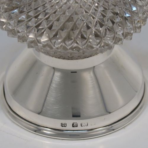 A handsome Antique Edwardian Sterling Silver and hand-cut crystal pepper grinder, having a round body with hobnail-cut pattern, plain round mounts top and bottom, a side-winding grinder arm with wooden finial, and an original Peugeot grinding mechanism. This elegant antique pepper grinder was made by Heath and Middleton of London in 1908. The dimensions of this fine hand-made silver and crystal pepper grinder are height 9 cms (3.5 inches), and diameter at base 6 cms (2.3 inches).