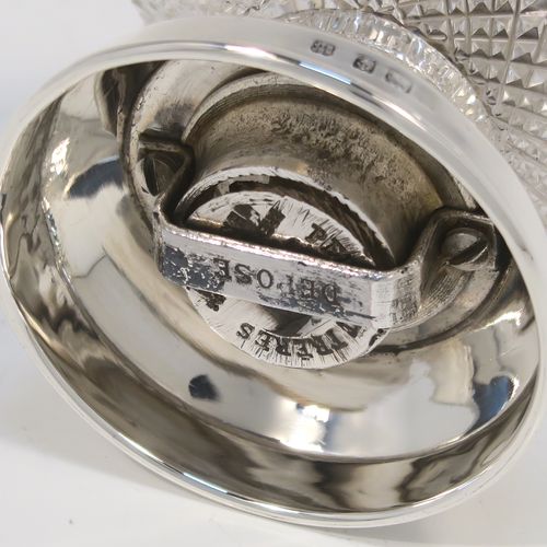 A handsome Antique Edwardian Sterling Silver and hand-cut crystal pepper grinder, having a round body with hobnail-cut pattern, plain round mounts top and bottom, a side-winding grinder arm with wooden finial, and an original Peugeot grinding mechanism. This elegant antique pepper grinder was made by Heath and Middleton of London in 1908. The dimensions of this fine hand-made silver and crystal pepper grinder are height 9 cms (3.5 inches), and diameter at base 6 cms (2.3 inches).