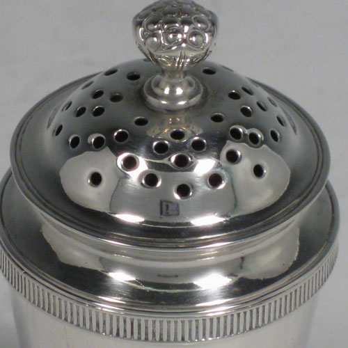 Antique Georgian sterling silver pepper pot (or possibly a pounce pot), having a plain round body with tapering sides, gadroon edge borders top and bottom, and a pull-off pierced lid with cast Cauliflower finial. Made by Michael Starkey of London in 1818. The dimensions of this fine hand-made silver pounce or pepper pot are height 8.5 cms (3.3 inches), diameter 4 cms (1.5 inches), and it weighs approx. 67g (2.2 troy ounces). Please note that this item is crested on one side with a Punch-like figure.