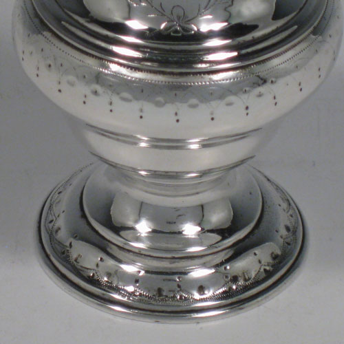 Antique Georgian sterling silver pepper pot, having a plain baluster body with a band of floral engraving and vacant laurel-leaf cartouche, a hand-pierced pull-off lid with swirl finial, and sitting on a pedestal foot with matching engraving. Made in London in 1771. The dimensions of this fine hand-made silver pepper pot are height 14 cms (5.5 inches), diameter of main body 5 cms (2 inches), and it weighs approx. 98g (3.2 troy ounces).