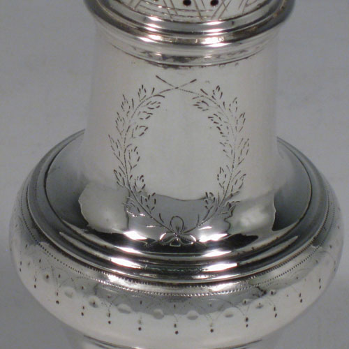 Antique Georgian sterling silver pepper pot, having a plain baluster body with a band of floral engraving and vacant laurel-leaf cartouche, a hand-pierced pull-off lid with swirl finial, and sitting on a pedestal foot with matching engraving. Made in London in 1771. The dimensions of this fine hand-made silver pepper pot are height 14 cms (5.5 inches), diameter of main body 5 cms (2 inches), and it weighs approx. 98g (3.2 troy ounces).