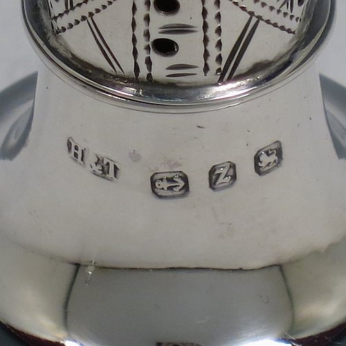 An Antique Victorian Sterling Silver pair of pepper pots, having plain round bellied bodies, with reeded borders, pull-off hand-pierced lids with ball finials, and sitting on pedestal feet. Made by Hilliard & Thomason of Birmingham in 1899. The dimensions of these fine hand-made antique silver pepper pots are height 7 cms (2.75 inches), diameter 3 cms (1.25 inches), and they weigh a total of approx. 43g (1.4 troy ounces). Please note that these items are crested.