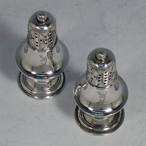 An Antique Victorian Sterling Silver pair of pepper pots, having plain round bellied bodies, with reeded borders, pull-off hand-pierced lids with ball finials, and sitting on pedestal feet. Made by Hilliard & Thomason of Birmingham in 1899. The dimensions of these fine hand-made antique silver pepper pots are height 7 cms (2.75 inches), diameter 3 cms (1.25 inches), and they weigh a total of approx. 43g (1.4 troy ounces). Please note that these items are crested.
