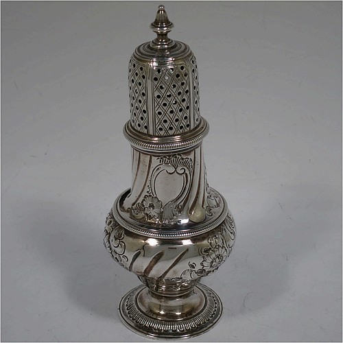 A very handsome Antique Georgian George III Sterling Silver pepper pot, having a baluster body with hand-chased fluted and floral decoration, applied rope-twist borders, a hand-pierced pull-off lid with urn finial, and sitting on a pedestal foot. Made by William Turton of London in 1777. The dimensions of this fine hand-made antique silver pepper pot are height 15 cms (6 inches), diameter of main body 6 cms (2.25 inches), and it weighs approx. 142g (4.6 troy ounces).    