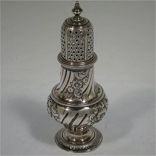 A very handsome Antique Georgian George III Sterling Silver pepper pot, having a baluster body with hand-chased fluted and floral decoration, applied rope-twist borders, a hand-pierced pull-off lid with urn finial, and sitting on a pedestal foot. Made by William Turton of London in 1777. The dimensions of this fine hand-made antique silver pepper pot are height 15 cms (6 inches), diameter of main body 6 cms (2.25 inches), and it weighs approx. 142g (4.6 troy ounces).