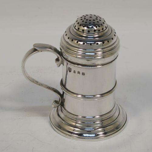 A very handsome Silver Kitchen pepper made in the Britannia Standard, having a plain round straight-sided body with an applied central girdle, a pull-off hand-pierced lid, a cast scroll side-handle, and siting on a stepped collet foot. This Britannia Standard silver kitchen pepper pot was made by the Pairpoint Brothers of London in 1929. The dimension of this silver kitchen pepper are height 7.5 cms (3 inches), length 7 cms (2.75 inches), and it weighs approx. 149g (4.8 troy ounce).   