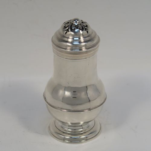 A very handsome Antique Georgian George I Britannia standard silver Bun style pepper pot, having a plain round bellied body, with applied reeded borders, a pull-off pierced lid, and sitting on a pedestal foot. This elegant antique Georgian silver bun pepper was made by George Greenhill Jones London in 1723. The dimensions of this fine hand-made Britannia standard silver pepper pot are height 11 cms (4.25 inches), diameter of main body 5 cms (2 inches), and it weighs approx. 110g (3.5 troy ounces).   