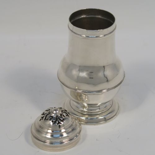 A very handsome Antique Georgian George I Britannia standard silver Bun style pepper pot, having a plain round bellied body, with applied reeded borders, a pull-off pierced lid, and sitting on a pedestal foot. This elegant antique Georgian silver bun pepper was made by George Greenhill Jones London in 1723. The dimensions of this fine hand-made Britannia standard silver pepper pot are height 11 cms (4.25 inches), diameter of main body 5 cms (2 inches), and it weighs approx. 110g (3.5 troy ounces).