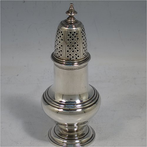 An Antique Georgian George II Sterling Silver pepper pot, having a plain bellied body with applied reeded borders, a hand-pierced pull-off lid with urn-shaped finial, and sitting on a pedestal foot. Made by Samuel Woods of London in 1752. The dimensions of this fine hand-made antique silver pepper pot are height 12 cms (4.75 inches), diameter of main body 5 cms (2 inches), and it weighs approx. 90g (3 troy ounces).    