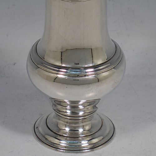 An Antique Georgian George II Sterling Silver pepper pot, having a plain baluster body with applied reeded borders, a hand-pierced pull-off lid with urn-shaped finial, and sitting on a pedestal foot. Made by Samuel Woods of London in 1758. The dimensions of this fine hand-made antique silver pepper pot are height 15 cms (6 inches), diameter of main body 5 cms (2 inches), and it weighs approx. 131g (4.2 troy ounces).