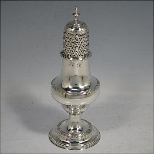 An Antique Georgian George II Sterling Silver pepper pot, having a plain bellied body with applied reeded borders, a hand-pierced pull-off lid with urn-shaped finial, and sitting on a pedestal foot. Made by Peter & William Bateman of London in 1807. The dimensions of this fine hand-made antique silver pepper pot are height 15 cms (6 inches), diameter of main body 5 cms (2 inches), and it weighs approx. 93g (3 troy ounces).   