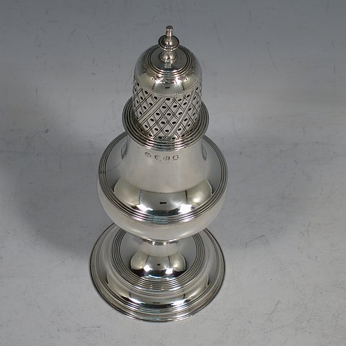 An Antique Georgian George II Sterling Silver pepper pot, having a plain bellied body with applied reeded borders, a hand-pierced pull-off lid with urn-shaped finial, and sitting on a pedestal foot. Made by Peter & William Bateman of London in 1807. The dimensions of this fine hand-made antique silver pepper pot are height 15 cms (6 inches), diameter of main body 5 cms (2 inches), and it weighs approx. 93g (3 troy ounces).
