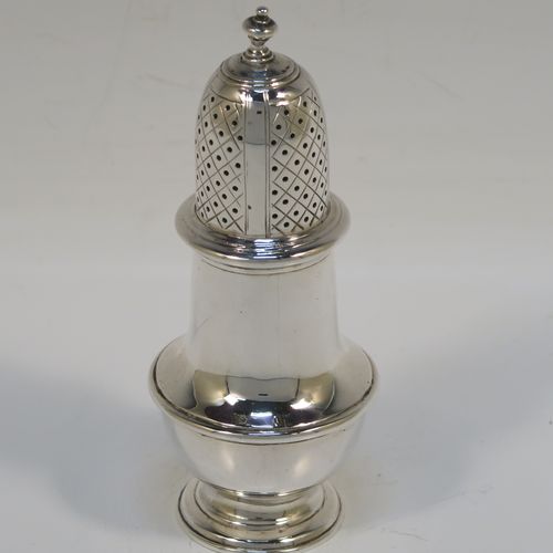 A very handsome Antique Sterling Silver pepper pot, in a Georgian style, having a plain round bellied body with applied reeded borders, a hand-pierced pull-off lid with urn-shaped finial, and sitting on a pedestal foot. This elegant silver pepper pot was made by Goldsmiths and Silversmiths of London in 1920. The dimensions of this fine hand-made antique silver pepper pot are height 11 cms (4.3 inches), diameter of main body 4.5 cms (1.75 inches), and it weighs approx. 105g (3.4 troy ounces).   