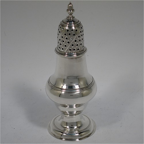 A very handsome Antique Georgian George III Sterling Silver pepper pot, having a plain baluster body with applied reeded borders, a hand-pierced pull-off lid with acorn finial, and sitting on a pedestal foot. Made by John Denziloe of London in 1779. The dimensions of this fine hand-made antique silver pepper pot are height 14 cms (5.5 inches), diameter of main body 5 cms (2 inches), and it weighs approx. 83g (2.7 troy ounces).   