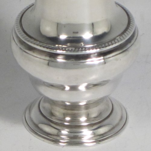 Antique Georgian sterling silver pepper pot, having a plain baluster body with an applied gadroon border, a hand-pierced pull-off lid with swirl finial, and sitting on a pedestal foot. Made by John Delmester of London in 1765. The dimensions of this fine hand-made silver pepper pot are height 11.5 cms (4.5 inches), diameter of main body 4.5 cms (1.75 inches), and it weighs approx. 72g (2.3 troy ounces).