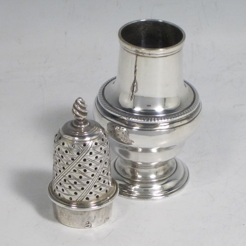 Antique Georgian sterling silver pepper pot, having a plain baluster body with an applied gadroon border, a hand-pierced pull-off lid with swirl finial, and sitting on a pedestal foot. Made by John Delmester of London in 1765. The dimensions of this fine hand-made silver pepper pot are height 11.5 cms (4.5 inches), diameter of main body 4.5 cms (1.75 inches), and it weighs approx. 72g (2.3 troy ounces).