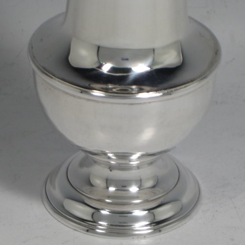 An Antique Georgian sterling silver pair of George II pepper pots, having plain round baluster bodies, with hand-pierced pull-off lids and finials, and sitting on pedestal feet. Made by Thomas Bamford I of London in 1730. The dimensions of these fine hand-made silver pepper pots are height 14.5 cms (5.75 inches), diameter of main body 5 cms (2 inches), and they weigh a total of approx. 257g (8.3 troy ounces).