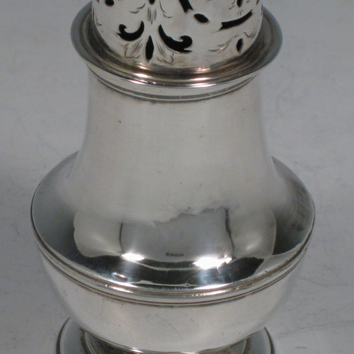 Antique Georgian sterling silver pepper pot, having a plain baluster body, a hand-pierced pull-off lid with finial, and sitting on a pedestal foot. Made by Thomas Rush of London in 1724. The dimensions of this fine hand-made silver pepper pot are height 14.5 cms (5.75 inches), diameter of main body 6 cms (2.25 inches), and it weighs approx. 131g (4.2 troy ounces).