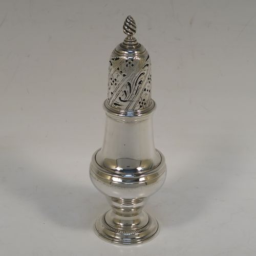 A handsome Antique Georgian Sterling Silver pepper pot, having a plain round bellied body, a hand-pierced pull-off lid with swirl finial, and sitting on a pedestal foot. This elegant antique silver pepper pot was made by John Delmester of London in 1764. The dimensions of this fine hand-made silver pepper pot are height 15 cms (6 inches), diameter of main body 5 cms (2 inches), and it weighs approx. 150g (4.8 troy ounces).   