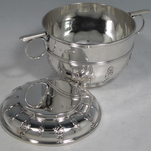 Antique Victorian sterling silver porringer and lid, having a round baluster body, a round lift-off lid, two oxe-eye side handles, all decorated with applied strap-work motifs, and sittng on a collet foot. Made by Holland, Aldwinckle, and Slater of London 1897. The dimensions of this fine hand-made silver porringer and lid are height 9 cms (3.5 inches), spread across arms 16. cms (6.5 inches), and it weighs approx. 324g (10.5 troy ounces).