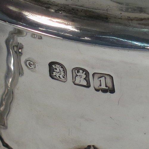 An Antique Edwardian Britannia Standard Silver porringer, having a round baluster body with a hand-hammered finish and hand-chased anthemion and floral decoration, a lift-off lid with matching floral work and a cast round finial, and two cast floral handles. Made by George Fox of London in 1906. The dimensions of this fine hand-made antique Britannia silver porringer and lid are height 11.5 cms (4.5 inches), spread across arms 16 cms (6.3 inches), and it weighs approx. 370g (12 troy ounces).