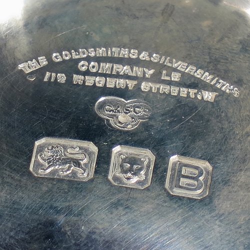 A heavy Sterling Silver three-handled porringer or loving cup, having a round body with tucked under belly and applied cut-card work, three cast scroll side-handles, and sitting on a pedestal foot. Made by Goldsmiths & Silversmiths of London in 1937. The dimensions of this fine hand-made silver loving cup or porringer are height 9.5 cms (3.75 inches), diameter 10 cms (4 inches), and it weighs approx. 417g (13.5 troy ounces).