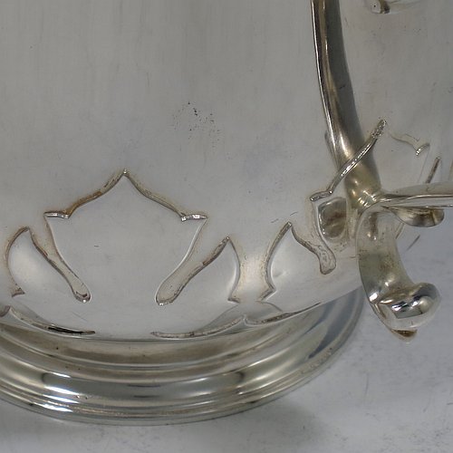 A heavy Sterling Silver three-handled porringer or loving cup, having a round body with tucked under belly and applied cut-card work, three cast scroll side-handles, and sitting on a pedestal foot. Made by Goldsmiths & Silversmiths of London in 1937. The dimensions of this fine hand-made silver loving cup or porringer are height 9.5 cms (3.75 inches), diameter 10 cms (4 inches), and it weighs approx. 417g (13.5 troy ounces).