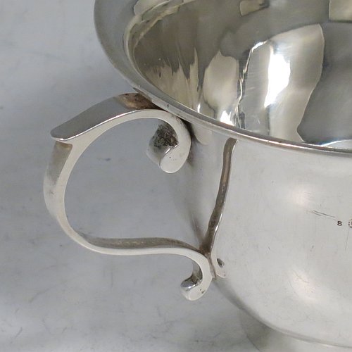 An Antique Edwardian Sterling Silver porringer, having a plain round baluster body, with two scroll side handles, and sitting on a collet foot. Made by Henry Hayes of Birmingham in 1902. The dimensions of this fine hand-made antique silver poringer are height 6.5 cms (2.5 inches), spread across arms 13 cms (5 inches), and it weighs approx. 125g (4 troy ounces).