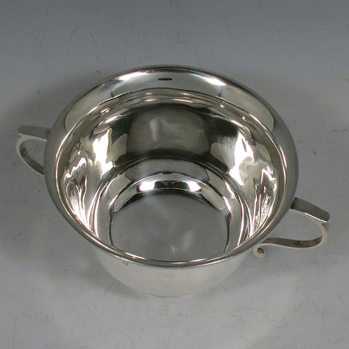 An Antique Edwardian Sterling Silver porringer, having a plain round baluster body, with two scroll side handles, and sitting on a collet foot. Made by Henry Hayes of Birmingham in 1902. The dimensions of this fine hand-made antique silver poringer are height 6.5 cms (2.5 inches), spread across arms 13 cms (5 inches), and it weighs approx. 125g (4 troy ounces).