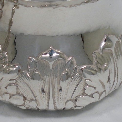 A heavy Sterling Silver porringer, having a round bellied body with a slight hand-hammered finish and hand-chased anthemion and floral decoration, and two cast side-handles with stylised dolphin heads. Made by Robert Comyns of London in 1931. The dimensions of this fine hand-made silver porringer are height 7 cms (2.75 inches), spread across arms 14 cms (5.5 inches), and it weighs approx. 247g (8 troy ounces).
