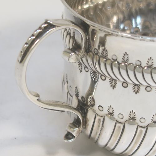 A very handsome Antique Edwardian Sterling Silver porringer, having a round bellied body with bands of hand-chased fluted decoration, two scroll side-handles, and sitting on a flat base. This elegant silver poringer was made by D. and J. Welby of London in 1906. The dimensions of this fine hand-made antique silver porringer are height 7 cms (2.75 inches), spread across handles 14 cms (5.5 inches), and it weighs approx. 182g (5.9 troy ounces).  